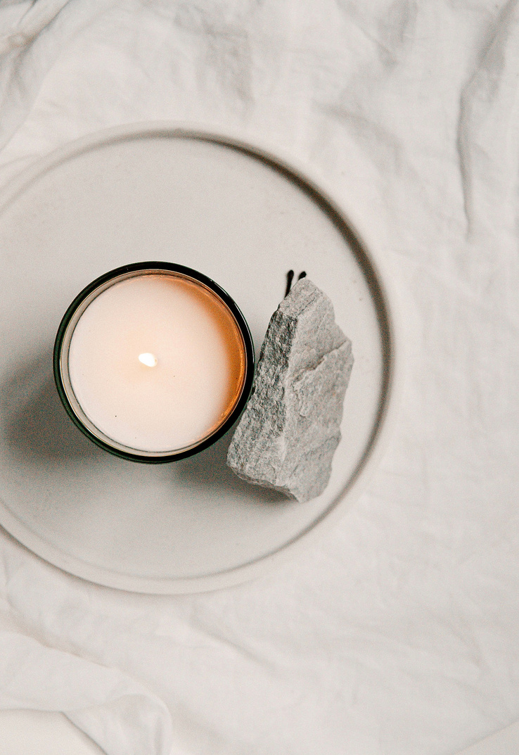 White Candle on White Ceramic Saucer